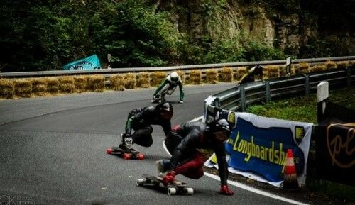 Downhill-Longboarder mit Motorrad Schutzausrüstung und Lederkombi.